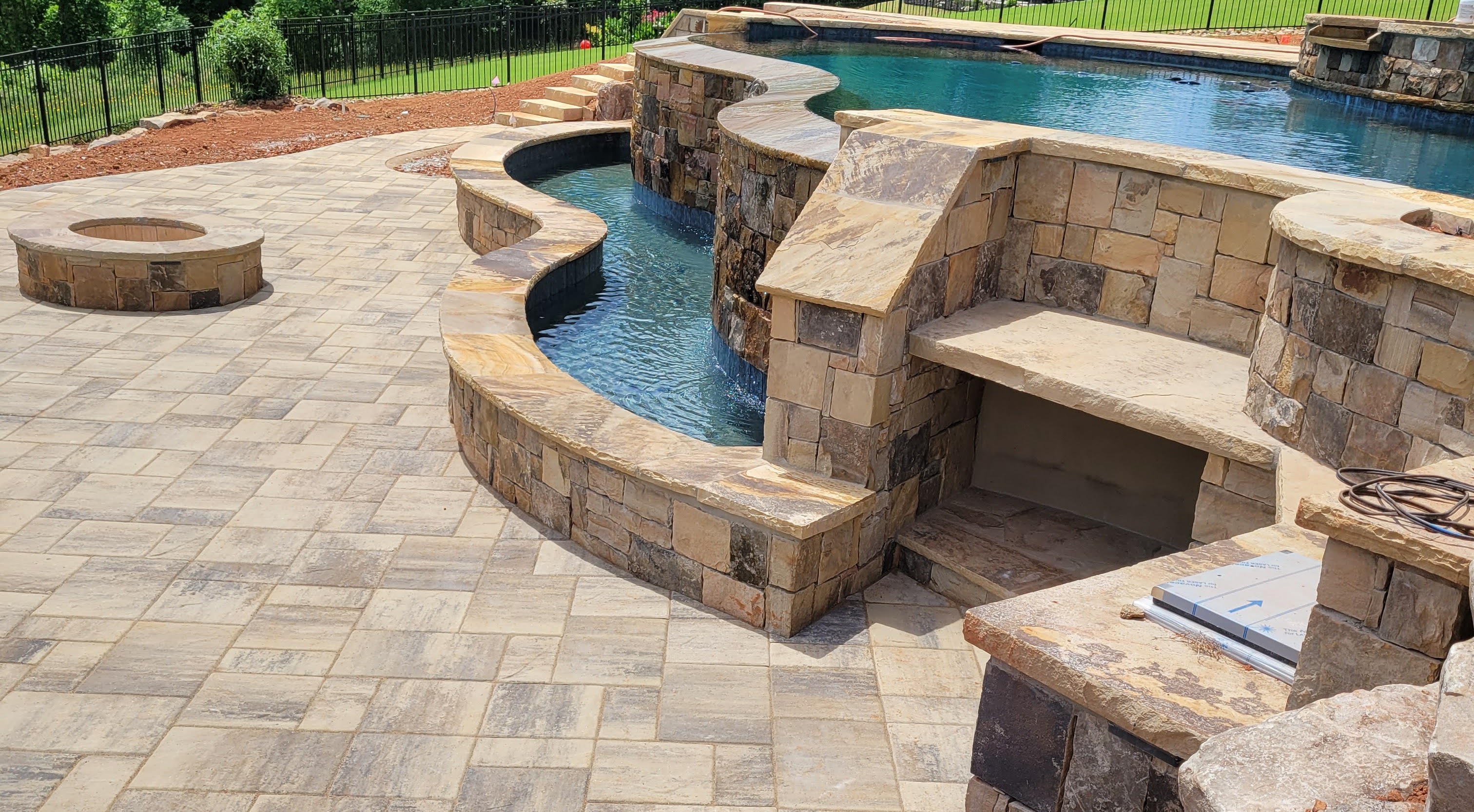 The image shows a newly installed paver patio in preparation of being sealed.